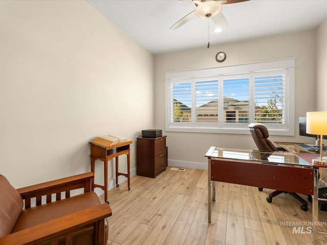 office space with a ceiling fan, baseboards, and light wood-style flooring