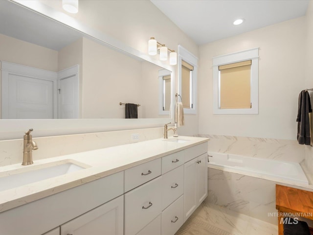 full bathroom featuring a bath, double vanity, a sink, and marble finish floor