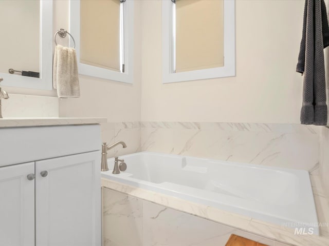 full bath featuring vanity and a bath