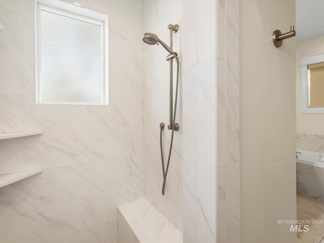 full bath featuring a healthy amount of sunlight and a marble finish shower