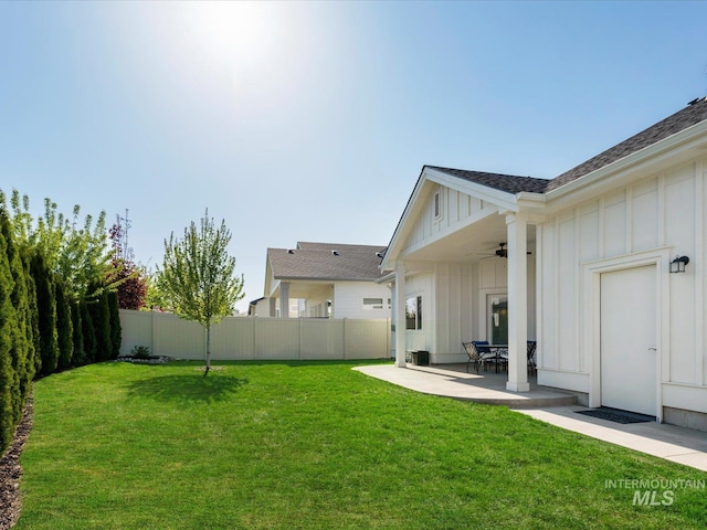 view of yard with ceiling fan, fence, and a patio area