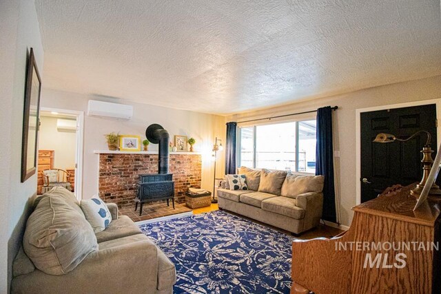 1627 Verdant Ct, Emmett, ID 83617 - living room featuring a wall mounted air conditioner, a wood stove, a textured ceiling, a wall mounted AC, and wood finished floors