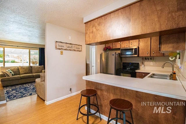 1627 Verdant Ct, Emmett, ID 83617 - kitchen with stainless steel appliances, a sink, a peninsula, baseboards, and light countertops
