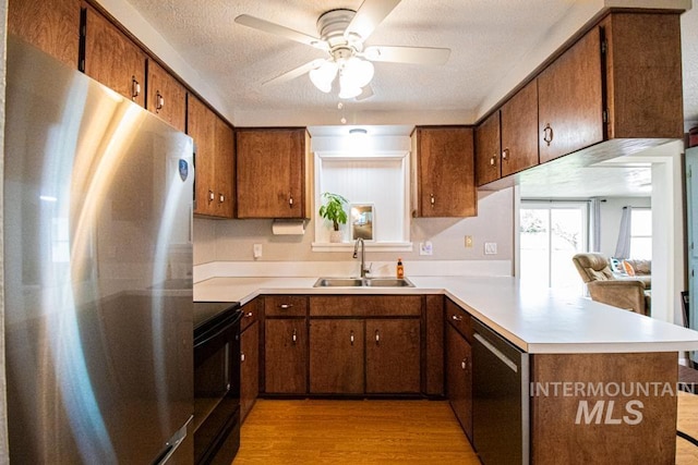 1627 Verdant Ct, Emmett, ID 83617 - kitchen featuring stainless steel appliances, a sink, a peninsula, ceiling fan, and light wood finished floors