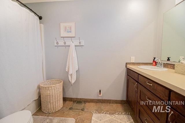 1627 Verdant Ct, Emmett, ID 83617 - full bathroom with vanity, toilet, baseboards, and curtained shower