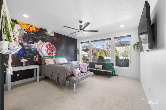 carpeted bedroom with ceiling fan and a textured ceiling