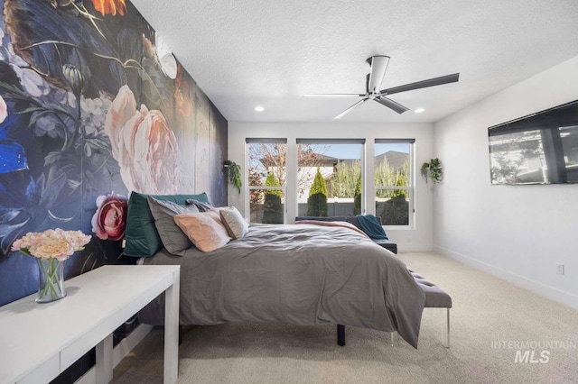 bedroom featuring ceiling fan, carpet, and a textured ceiling