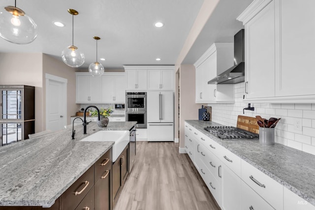 9478 W Napier St, Star, ID 83669 - kitchen featuring wall chimney range hood, appliances with stainless steel finishes, a sink, white cabinetry, and recessed lighting