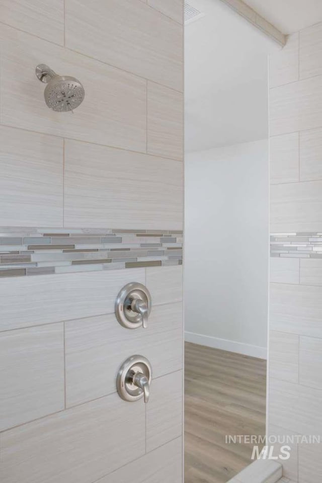 bathroom with hardwood / wood-style floors and walk in shower