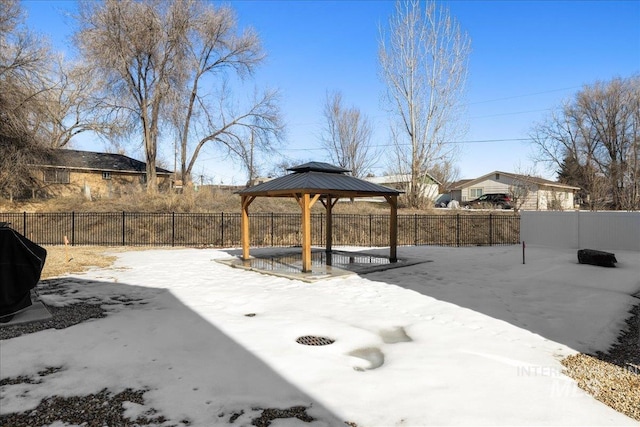 snow covered patio featuring fence and a gazebo