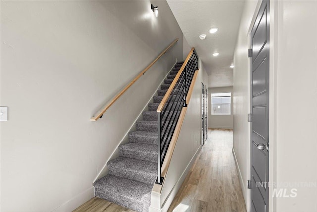 stairs featuring recessed lighting, baseboards, and wood finished floors