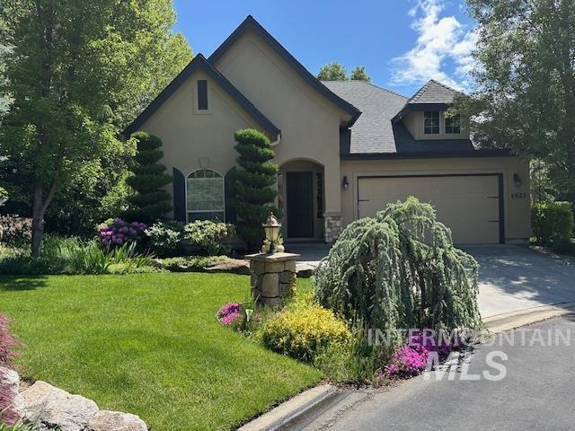 1923 S Stream Pointe Ln, Eagle, ID 83616 - view of front of home featuring concrete driveway, a front lawn, stucco siding, and a garage