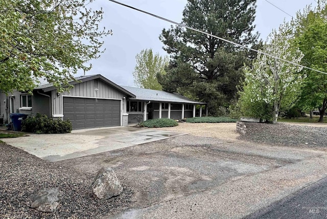 view of front of home featuring a garage, board and batten siding, concrete driveway, and brick siding