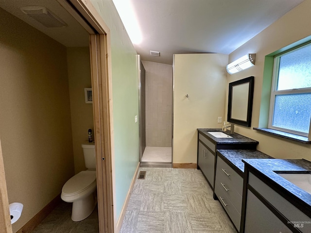 full bath featuring walk in shower, toilet, baseboards, two vanities, and visible vents