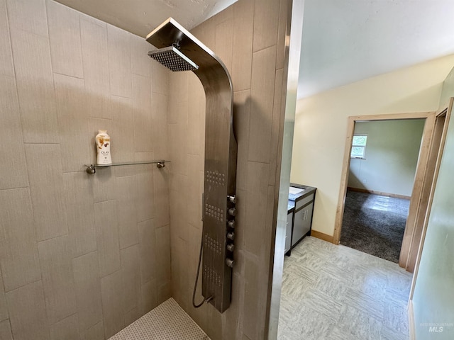 full bath with baseboards and tiled shower