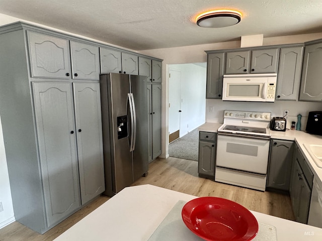 kitchen with white appliances, gray cabinets, and light wood-style floors