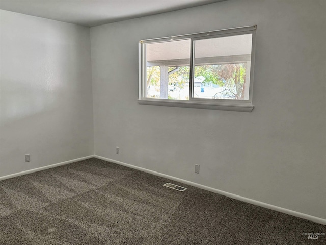 carpeted empty room featuring baseboards and visible vents