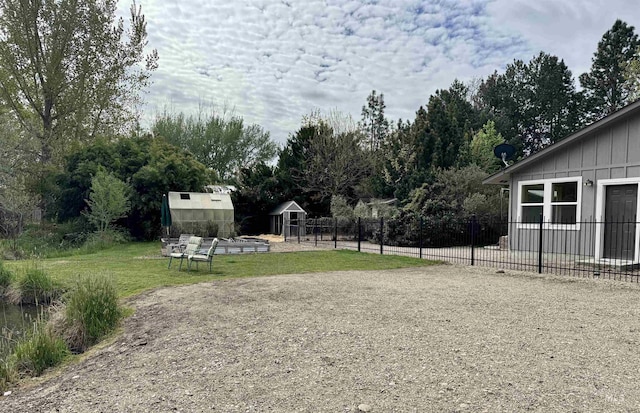 view of yard featuring fence, an outbuilding, and a storage shed