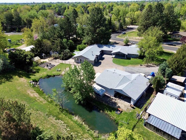drone / aerial view featuring a water view and a wooded view