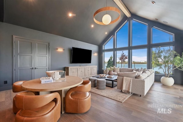 living room featuring beam ceiling, wood finished floors, and high vaulted ceiling