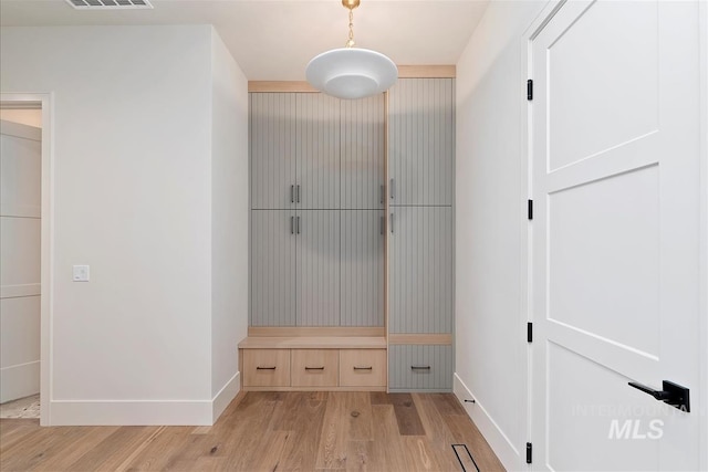 mudroom featuring baseboards, visible vents, and light wood-style floors
