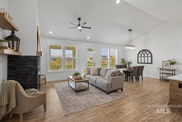 living room featuring ceiling fan, light hardwood / wood-style flooring, and lofted ceiling