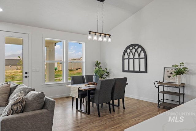 dining area with vaulted ceiling, a healthy amount of sunlight, and dark hardwood / wood-style floors