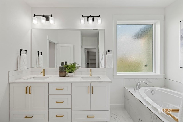 bathroom featuring vanity and tiled tub