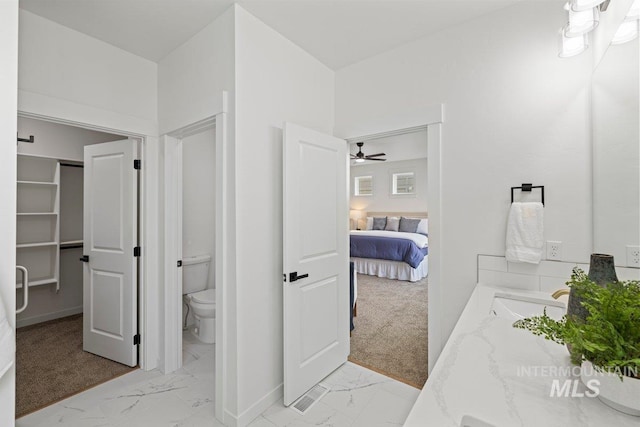 bathroom featuring vanity, toilet, and ceiling fan