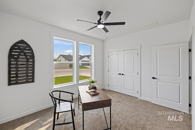 carpeted office space with ceiling fan