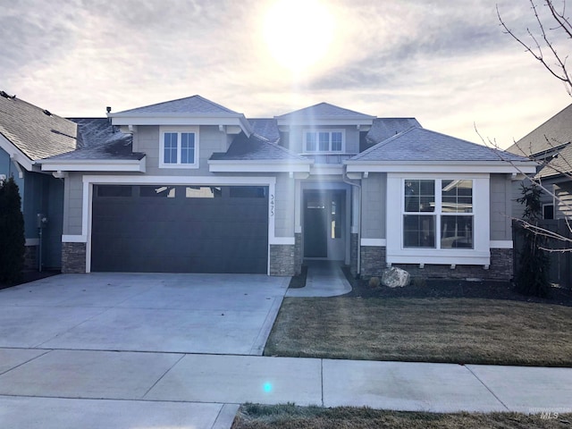 prairie-style home featuring a garage and a lawn