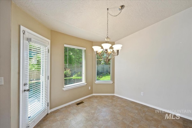 3804 Stonehedge Way, Caldwell, ID 83605 - unfurnished dining area featuring a chandelier, a textured ceiling, and healthy amount of natural light