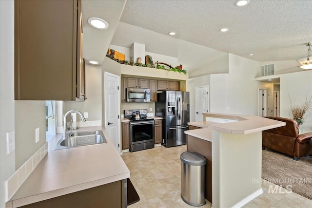 3804 Stonehedge Way, Caldwell, ID 83605 - kitchen with stainless steel appliances, a textured ceiling, light countertops, a kitchen island, and recessed lighting