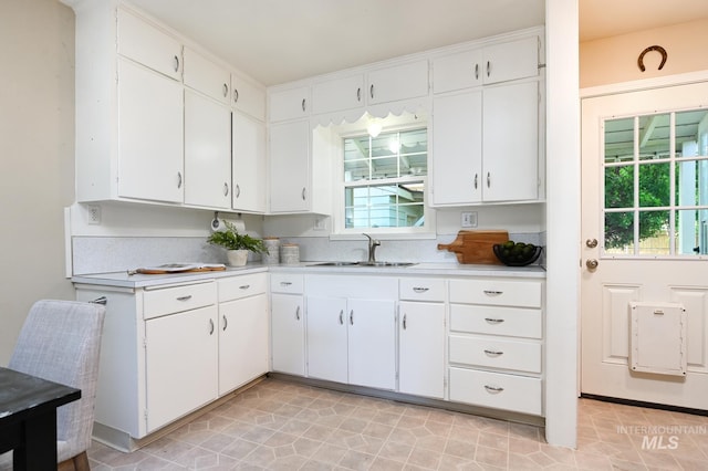 kitchen featuring white cabinets, a healthy amount of sunlight, and sink