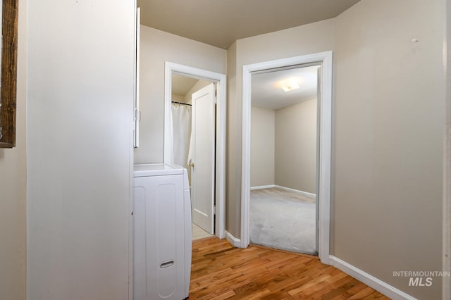 hall with washer / clothes dryer and light hardwood / wood-style floors