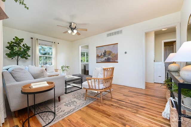 living room with ceiling fan and light hardwood / wood-style floors