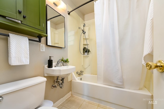 bathroom featuring toilet, shower / bath combo with shower curtain, and tile patterned flooring