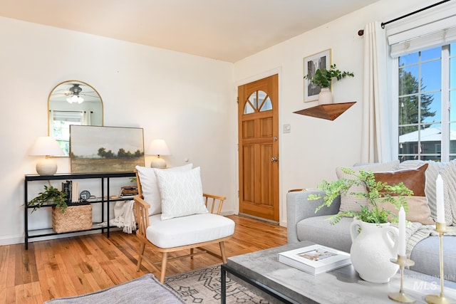 sitting room with hardwood / wood-style floors and ceiling fan