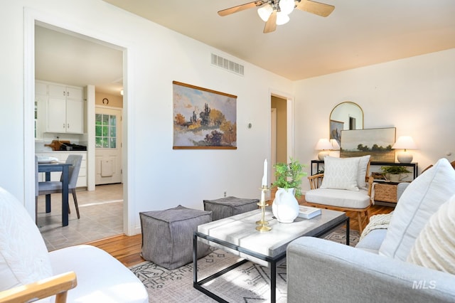 living room featuring light wood-type flooring and ceiling fan