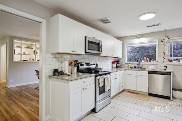 1207 N 19th St, Boise, ID 83702 - kitchen with stainless steel appliances, a sink, backsplash, and healthy amount of natural light