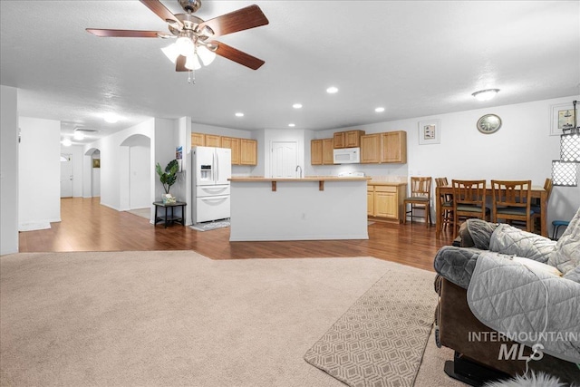 living room with dark hardwood / wood-style floors, sink, and ceiling fan