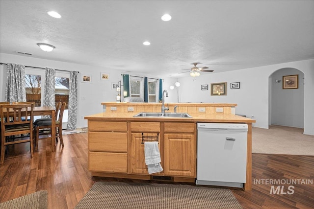 kitchen featuring dishwasher, sink, dark wood-type flooring, and an island with sink