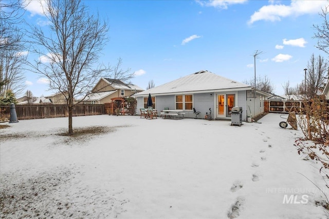 view of snow covered back of property