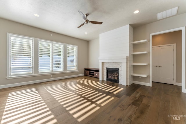 unfurnished living room with ceiling fan, dark wood-type flooring, and a textured ceiling