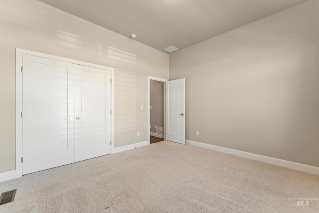 unfurnished bedroom featuring carpet flooring and a closet