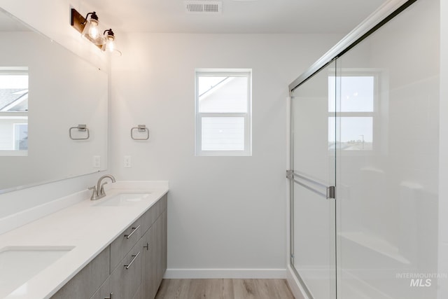 2827 N Rocky Bottom Way, Kuna, ID 83634 - full bathroom with wood finished floors, a stall shower, double vanity, and baseboards