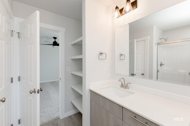 2827 N Rocky Bottom Way, Kuna, ID 83634 - full bathroom with a shower with shower door, a ceiling fan, vanity, and wood finished floors