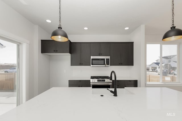 2827 N Rocky Bottom Way, Kuna, ID 83634 - kitchen featuring appliances with stainless steel finishes, light countertops, plenty of natural light, tasteful backsplash, and recessed lighting