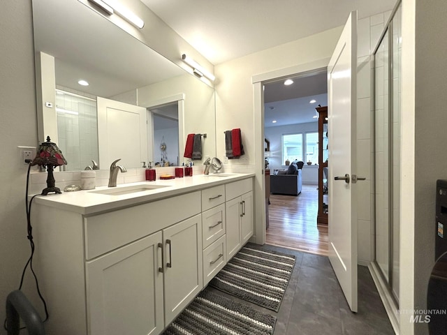 bathroom with double vanity, recessed lighting, a shower stall, and a sink