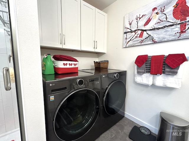 washroom featuring washing machine and clothes dryer, cabinet space, and baseboards